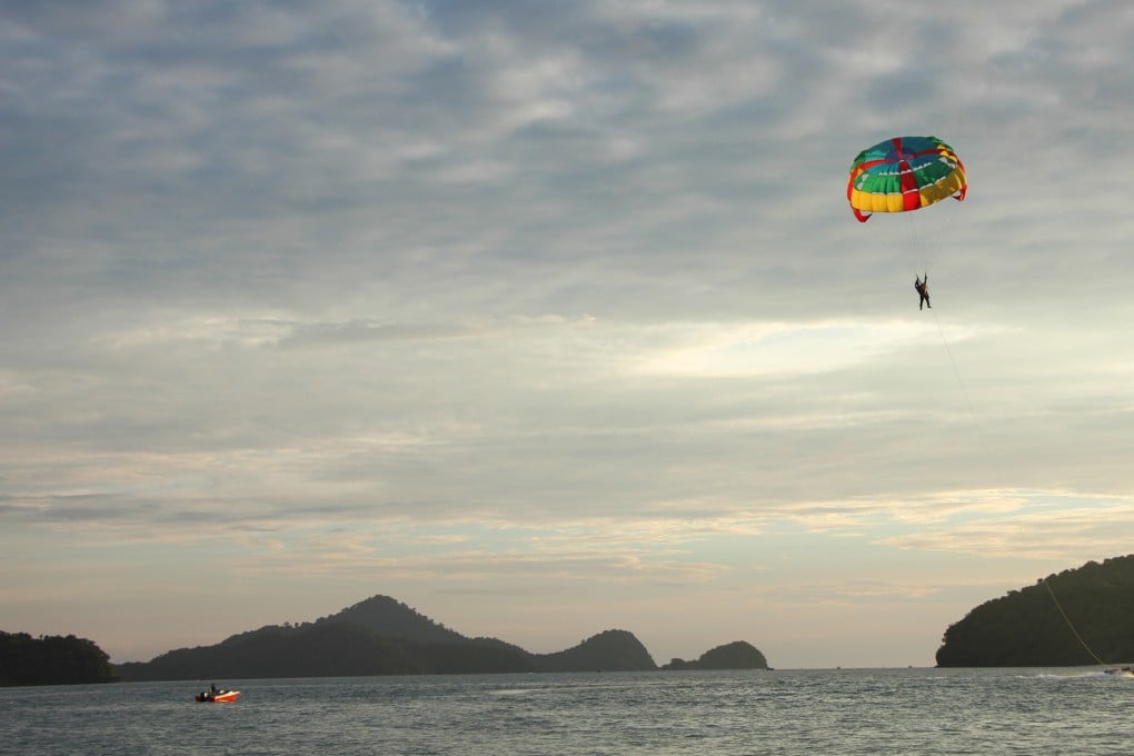 A paraglider being pulled by a fast speed boat along the coast of Langkawi, Malaysia. Photo: John Brunton
