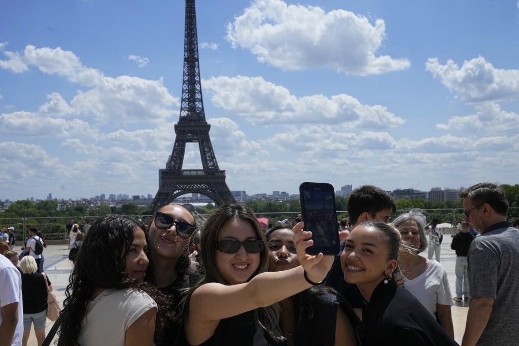 Tourists in Paris pose for a selfie with the Eiffel Tower in the background. From France to Aruba, more tourists are treating historical sites as merely boxes to tick off a list and reducing them to social media backdrops. Photo: AP