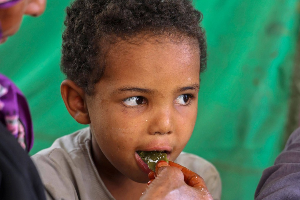 Displaced Yemeni woman Saeedah Mohammed feeds one of her grandchildren with boiled tree leaves. Photo: AFP