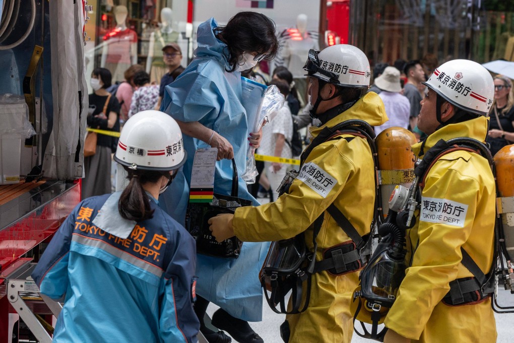 Emergency personnel help a woman who was inside the Ginza Six Shopping Centre on Monday. Photo:  AFP