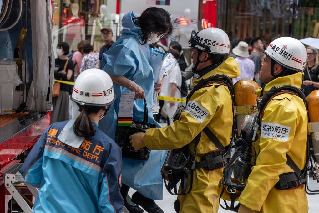 Emergency personnel help a woman who was inside the Ginza Six Shopping Centre on Monday. Photo: AFP