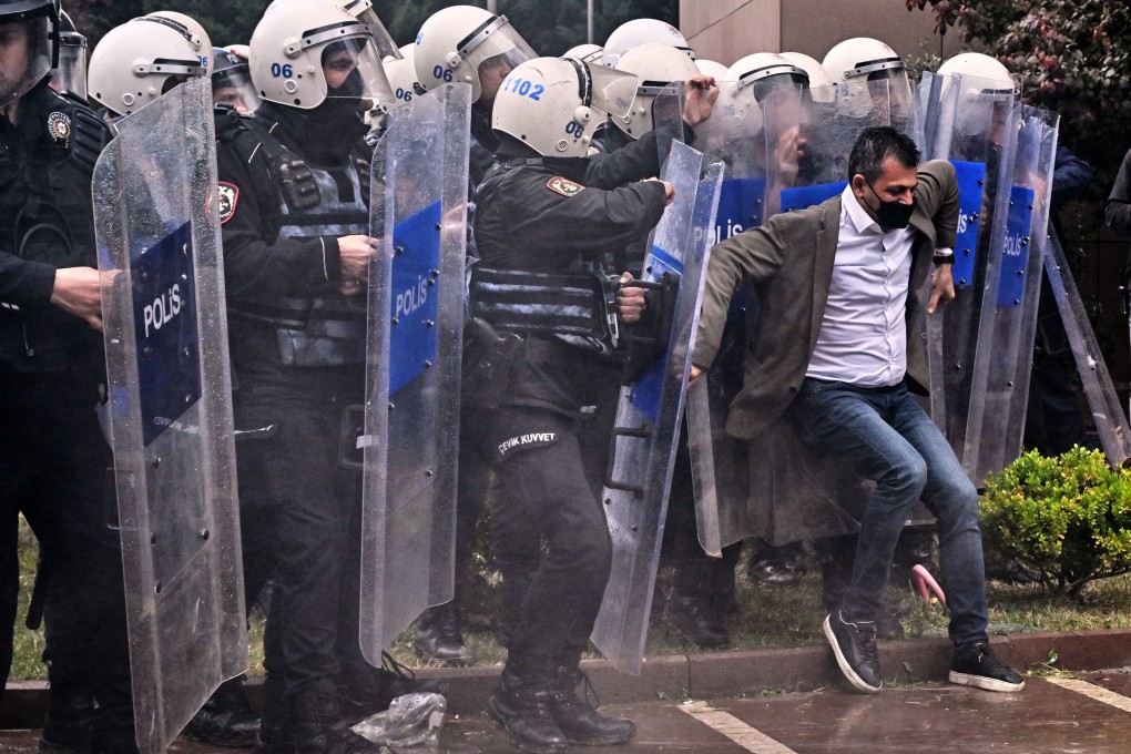 A man is pushed back by Turkish security forces clad in tactical gear during a raid on the CHP building in Ankara on Sunday. Photo: AP