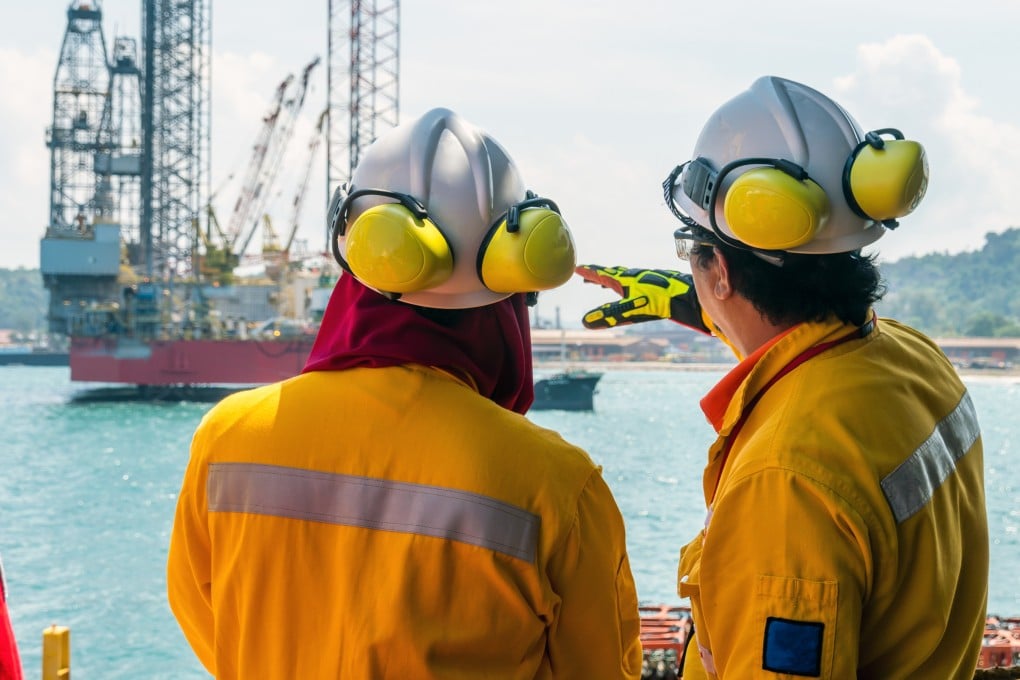 A construction supervisor briefs a fellow worker during mobilisation of a work barge at Kemaman Supply Base port in Terengganu. Photo: Shutterstock
