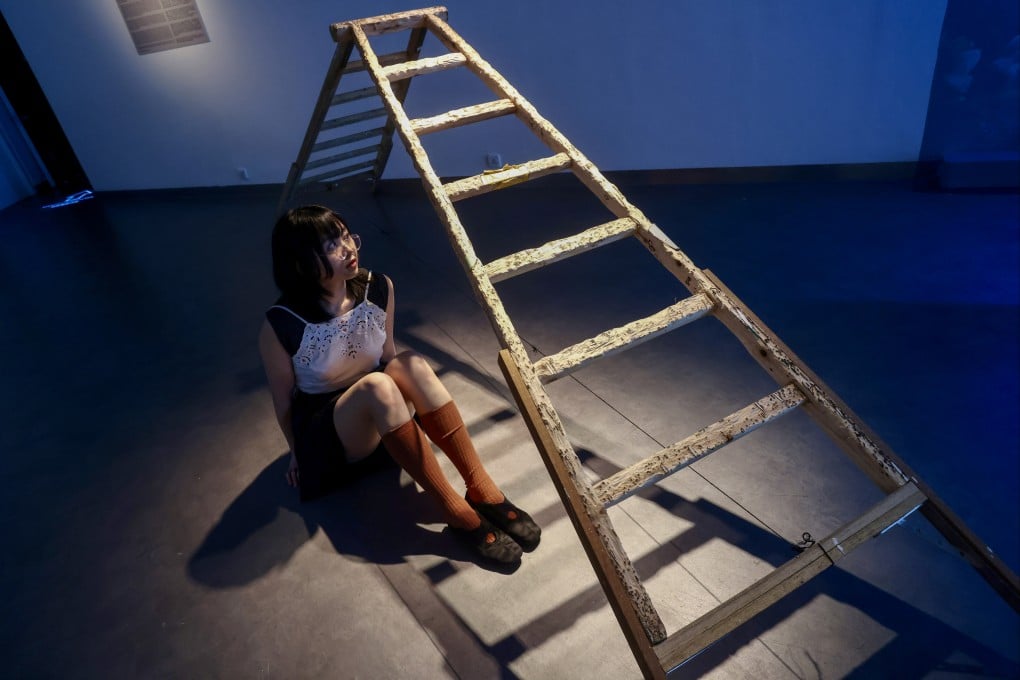 Artist Bethany Man sits next to her work Retired A-frame at the “Free Radicals” art exhibition at the Goethe Gallery and Black Box Studio at the Hong Kong Arts Centre. Photo: Jonathan Wong