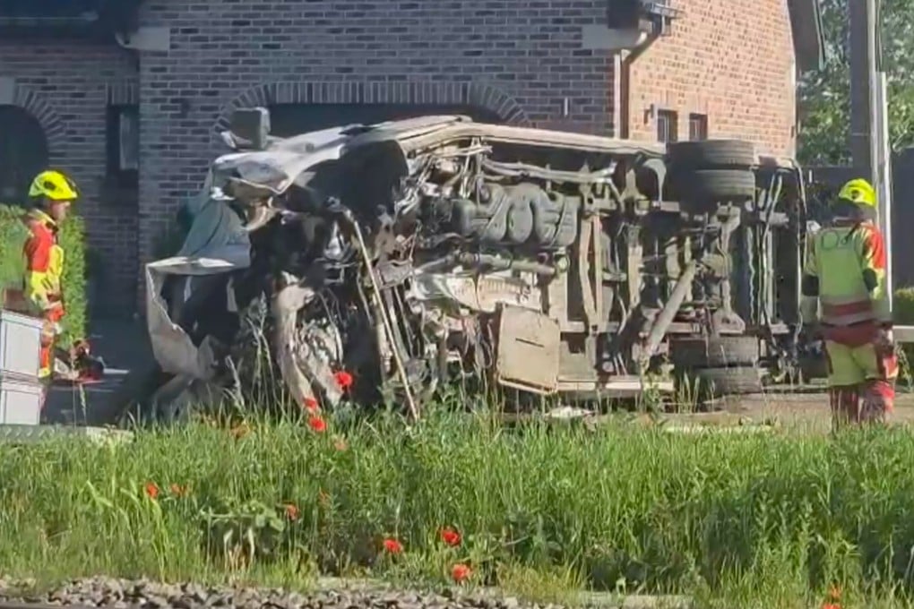 Rescuers work at the scene of a crash between a train and school bus in Buggenhout, Belgium, on Tuesday. Photo: VTM/AP