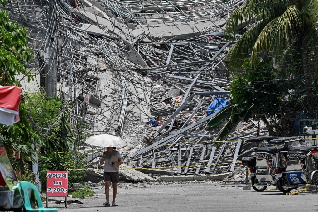 A resident walks past the rubble of a collapsed building in Angeles City, the Philippines, on Monday. Photo: AFP