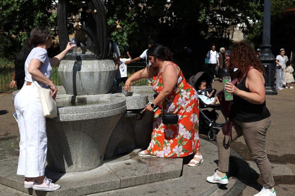 People refill their water bottles from a fountain in Green Park, London, during a heatwave on Monday. Photo: Reuters