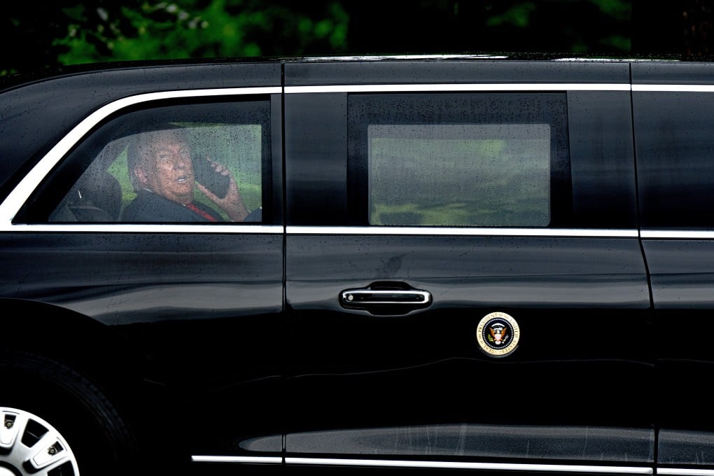 US President Donald Trump speaks on the phone inside his limousine on Monday. Photo: EPA