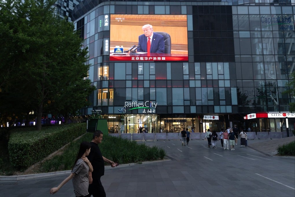 People walk past a TV screen broadcasting US President Donald Trump’s visit, in Beijing, China, on May 14. Photo; EPA