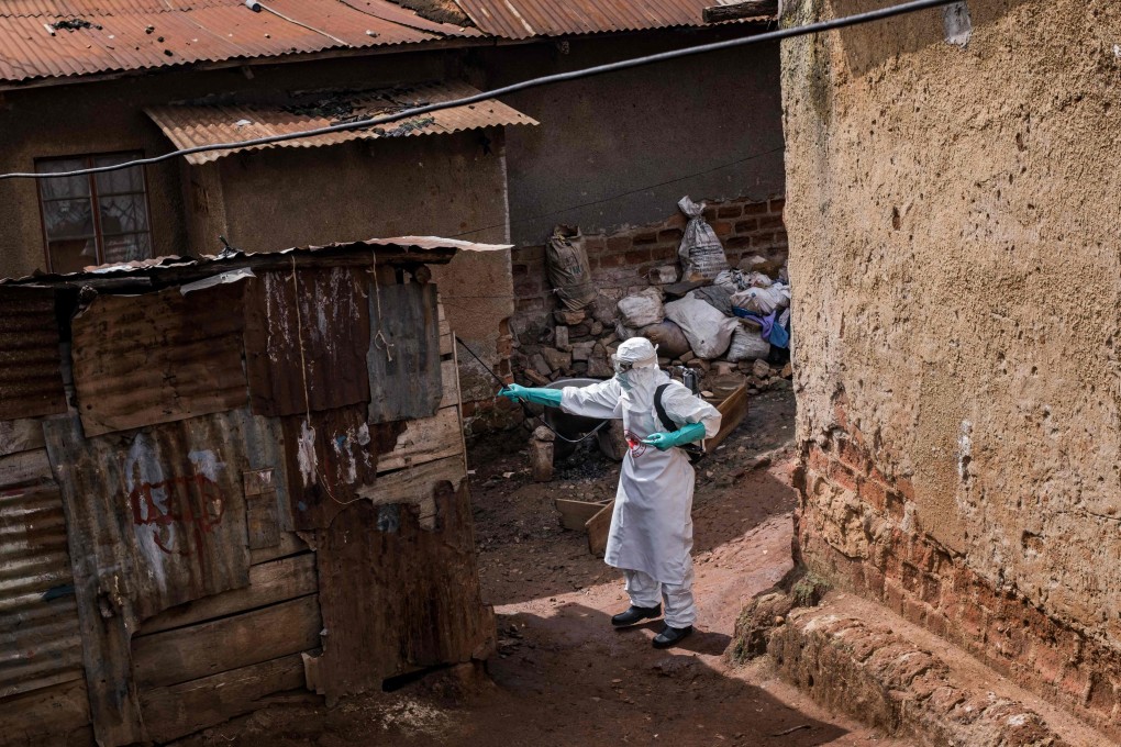 A Uganda Red Cross Society worker in protective gear sprays disinfectant at the home of a suspected Ebola victim in Kampala on Tuesday. Photo: AFP