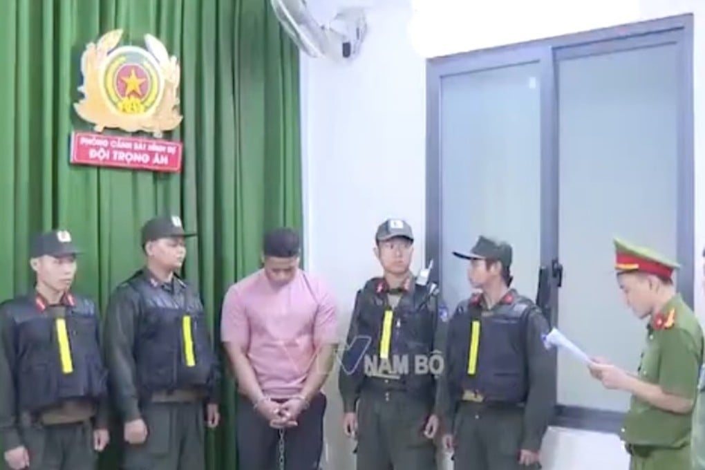 Steve Tafia, a Samoan suspect who is accused of the gun killing of an Australian gangster in Ho Chi Minh City, stands alongside Vietnamese police officers. Photo: X/Jacob in Cambodia