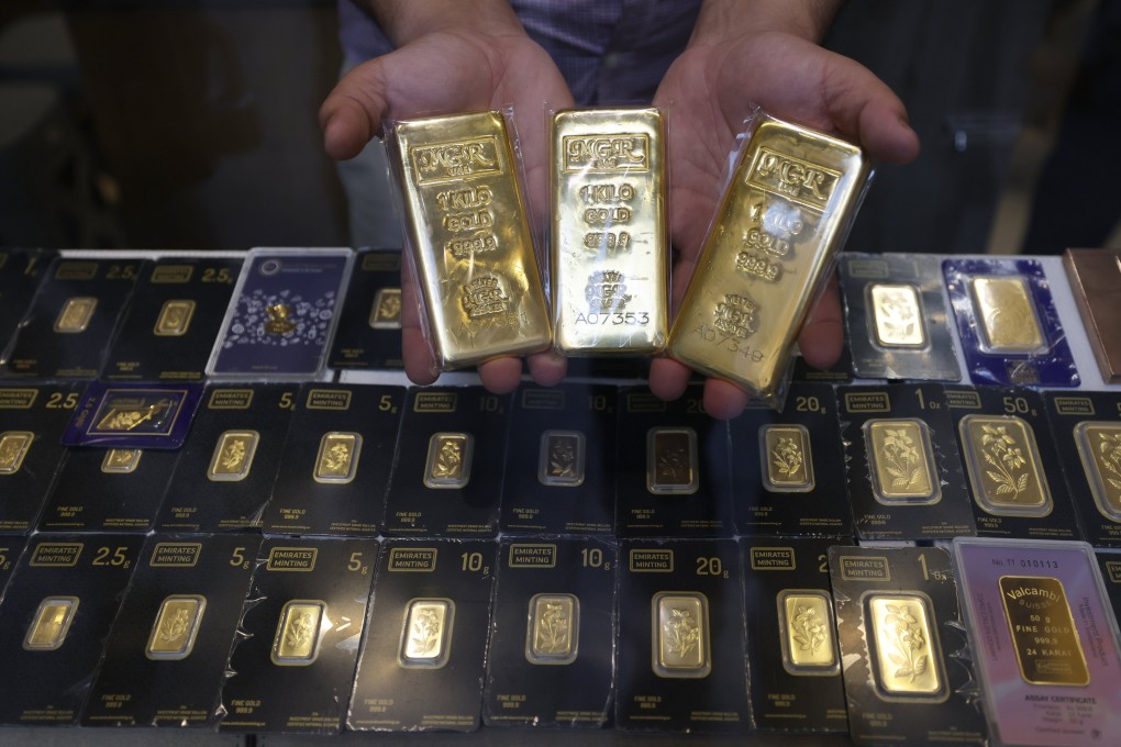 A salesman presents gold bars at a jewellery shop inside the Gold Market at the Old Souk in Dubai, United Arab Emirates on April 13. Photo: EPA
