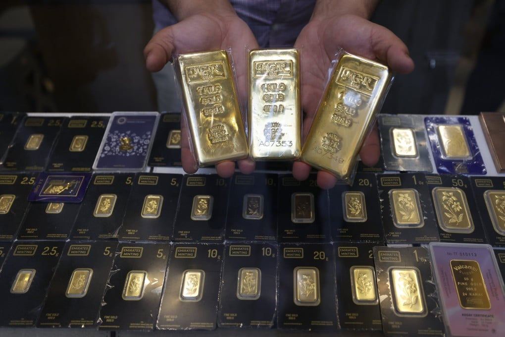 A salesman presents gold bars at a jewellery shop inside the Gold Market at the Old Souk in Dubai, United Arab Emirates on April 13. Photo: EPA