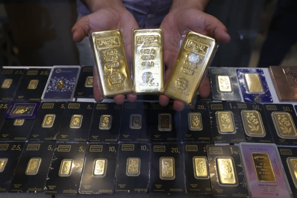 A salesman presents gold bars at a jewellery shop in Dubai, United Arab Emirates, last month. Photo: EPA