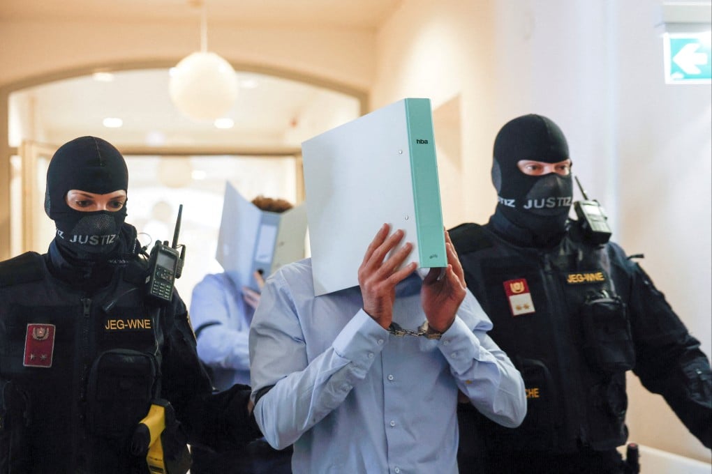‘Beran A’ being escorted by security personnel for his trial. Photo: Reuters
