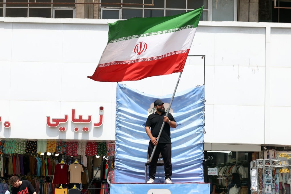 A man waves an Iranian flag in Tehran’s Valiasr Square as uncertainty surrounds a proposed peace deal. Photo: EPA
