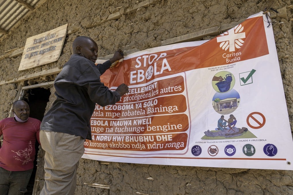 A man hangs an Ebola awareness banner in the Kigonze camp in Bunia, in the eastern Democratic Republic of the Congo on Thursday. Photo: TNS