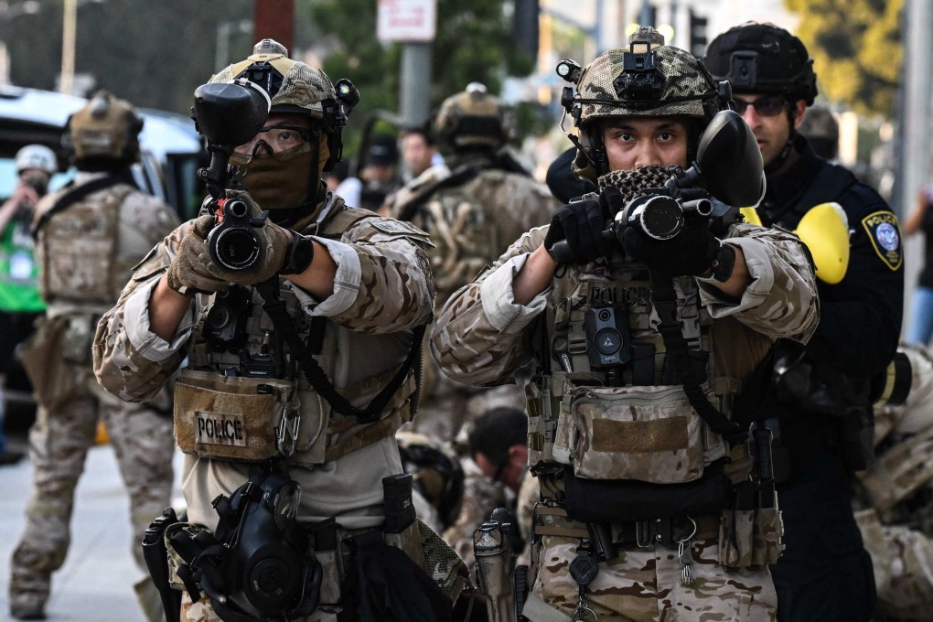 US Customs and Border Protection agents hold up less-lethal weapons in front of a federal building during a protest against the Trump administration’s immigration raids in Los Angeles last year. Photo: AFP