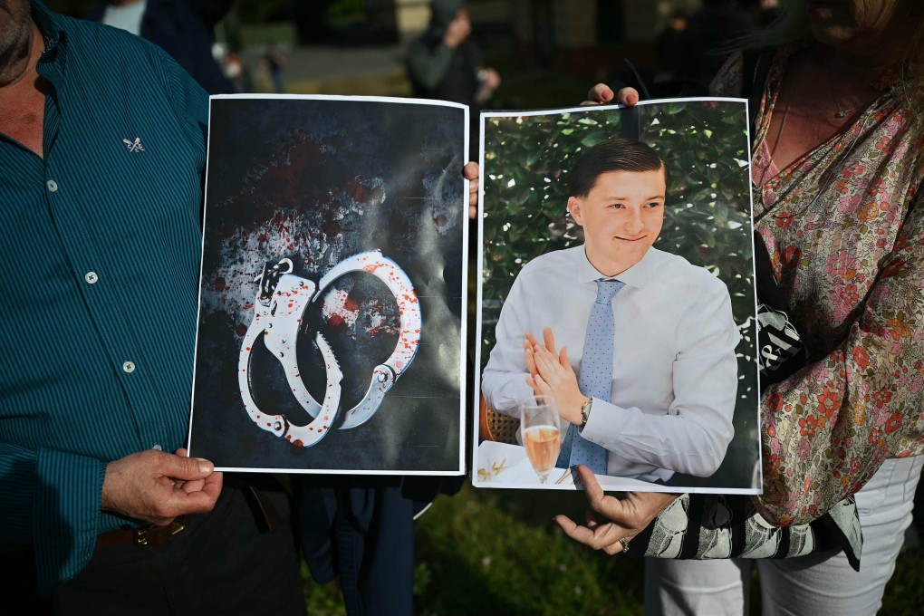 People hold images of victim Henry Nowak as they take part in a protest in Southampton on Tuesday following the murder of Nowak by Vickrum Digwa. Photo: AFP
