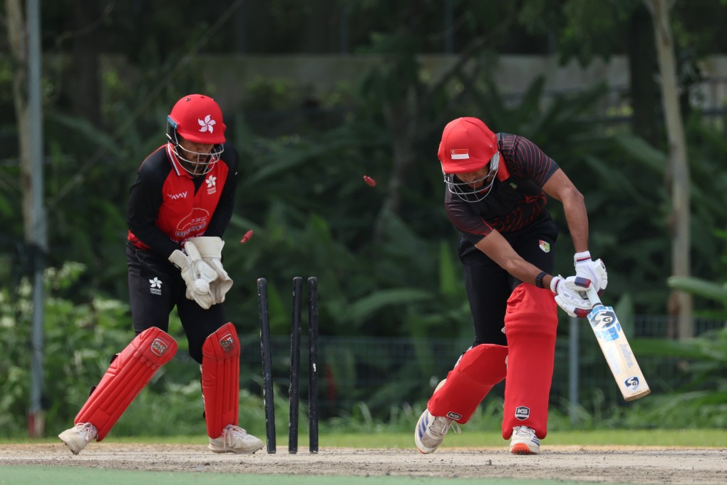 Hong Kong wicketkeeper Shahid Wasif (left) watches on as another Singapore wicket falls to the leg spin of Mohammad Ghazanfar. Photo: Handout