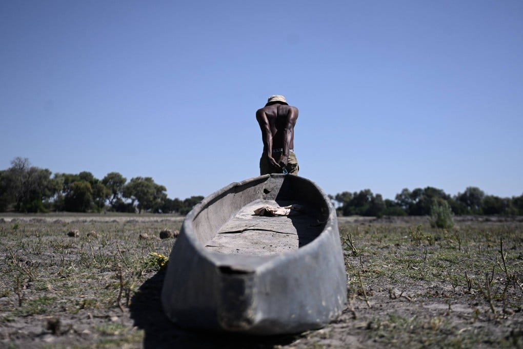 A man drags a traditional boat across a dried-up channel in the Okavango Delta, Botswana. The UN has warned countries to prepare for severe droughts. Photo: AFP