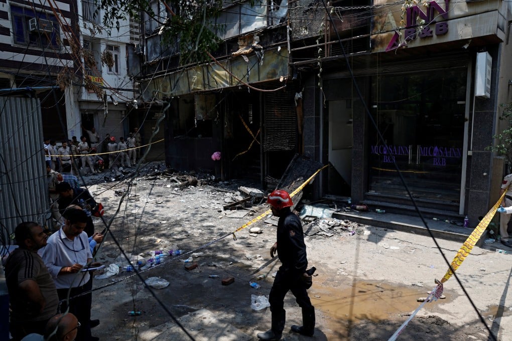 Firefighters and police officers work at the site after a fire at a hotel in New Delhi, India on Wednesday. Photo: Reuters