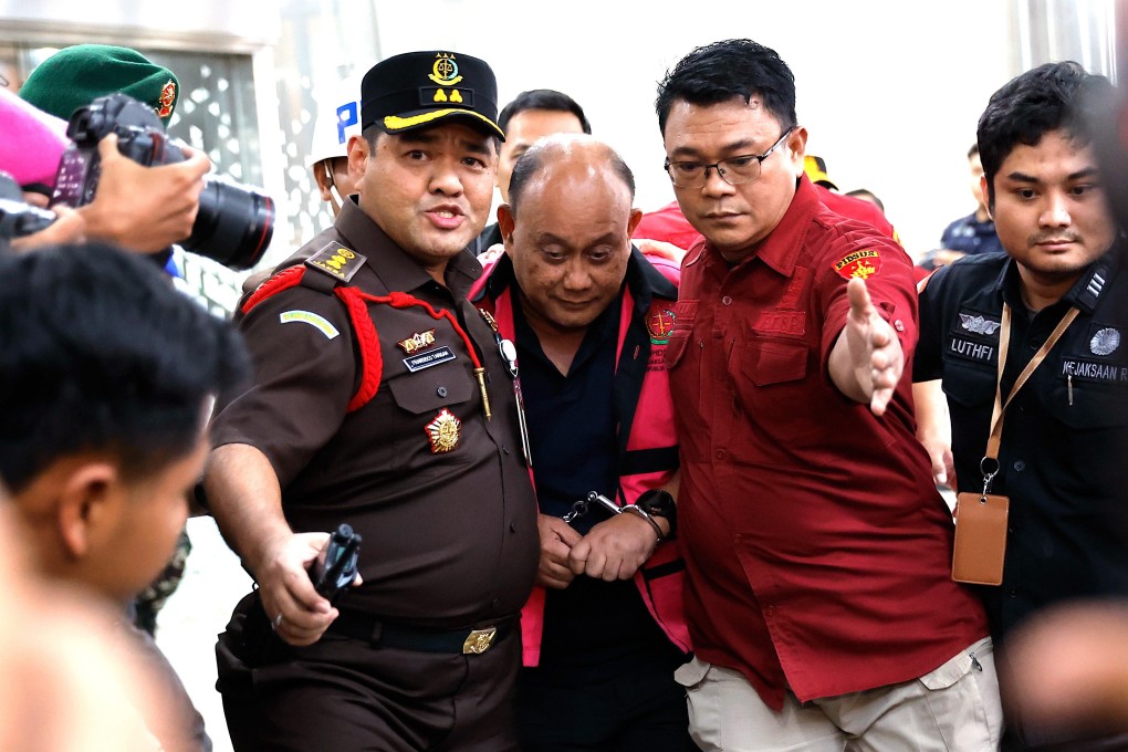 Prosecutors escort former head of the National Nutrition Agency Dadan Hindayana (middle) to a detention vehicle after he was named a suspect in a corruption case at the attorney general’s office in Jakarta on Wednesday. Photo: EPA