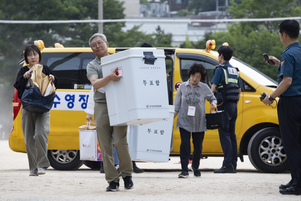 Election officials carry ballot boxes at a counting station in Seoul after voting in the national local elections closed on Wednesday. Photo: EPA