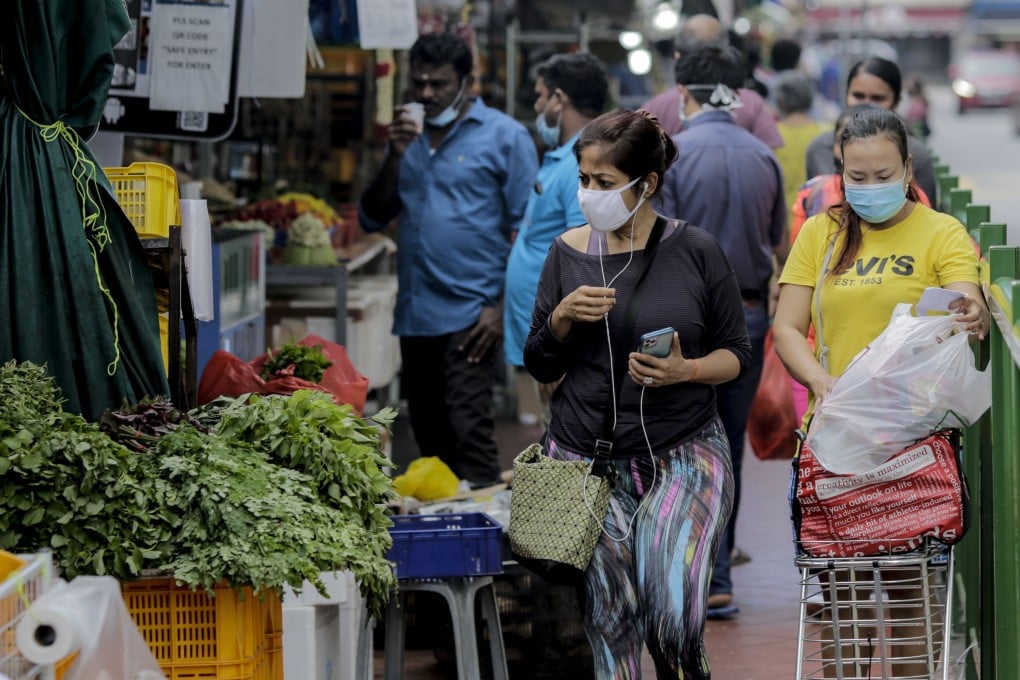 A woman inspects a vegetable stall in the Little India district of Singapore in July 2020. Photo: EPA-EFE