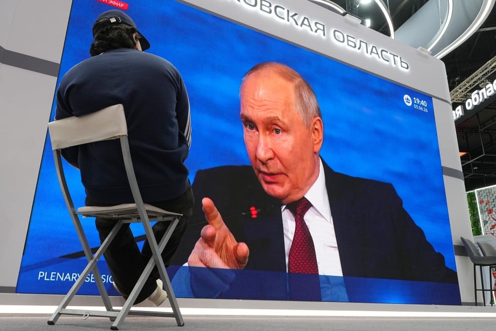A participant watches a broadcast of Russian President Vladimir Putin’s speech on a screen during the St Petersburg International Economic Forum on Friday. Photo: AP