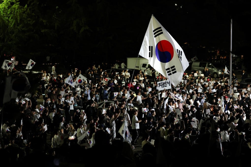 A large South Korean flags flies over protesters as they surround a vote-counting centre during a rally in Seoul on Saturday. Photo: Reuters