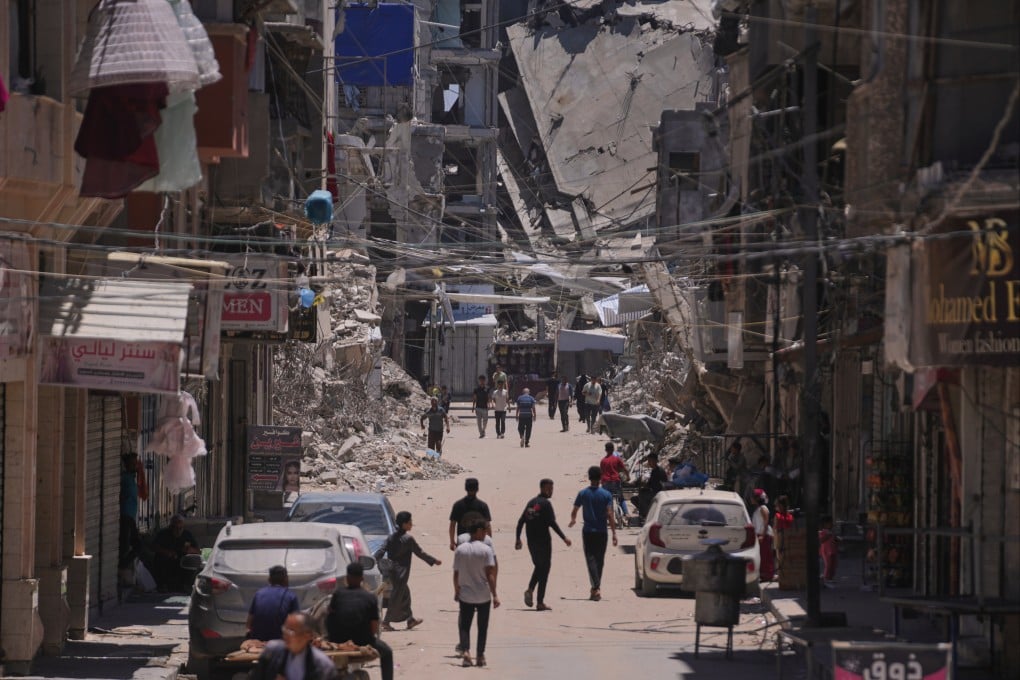 Palestinians walk along a street surrounded by buildings destroyed by Israeli military strikes in Khan Younis, southern Gaza Strip, last month. Photo: AP