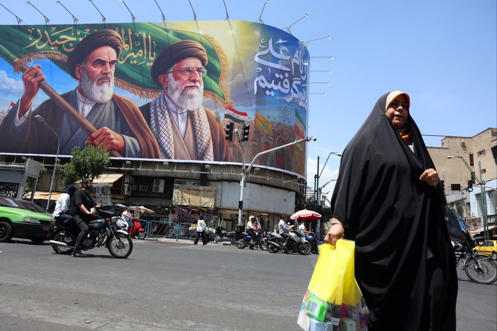 Iranians walk past a huge billboard featuring previous supreme leaders Ayatollah Ruhollah Khomeini and Ayatollah Ali Khamenei, on a street in Tehran, Iran, on Sunday. Photo: EPA-EFE