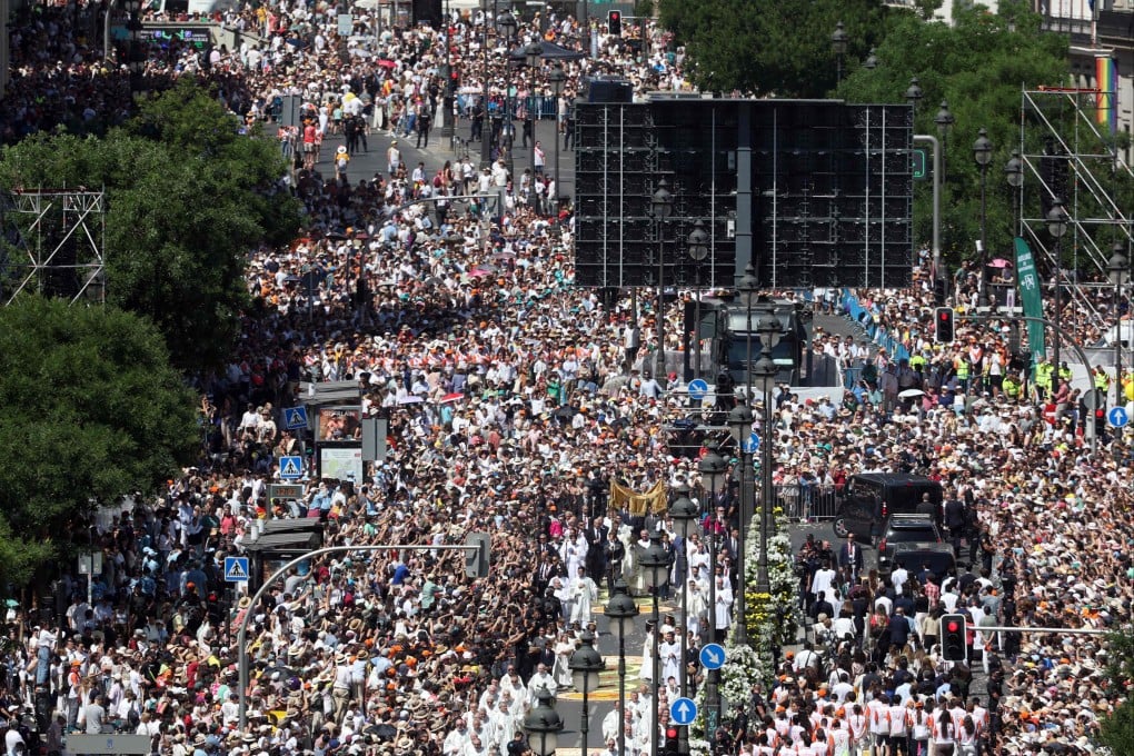A crowd packs Alcala street as Pope Leo walks under a processional canopy during the Corpus Christi procession following the Mass held in the Plaza de Cibeles in Madrid, Spain on Sunday. Photo: AFP