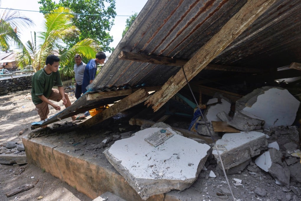 People collect their belongings from a damaged house following an earthquake off the southern Philippine island of Mindanao on Monday. Photo: Reuters