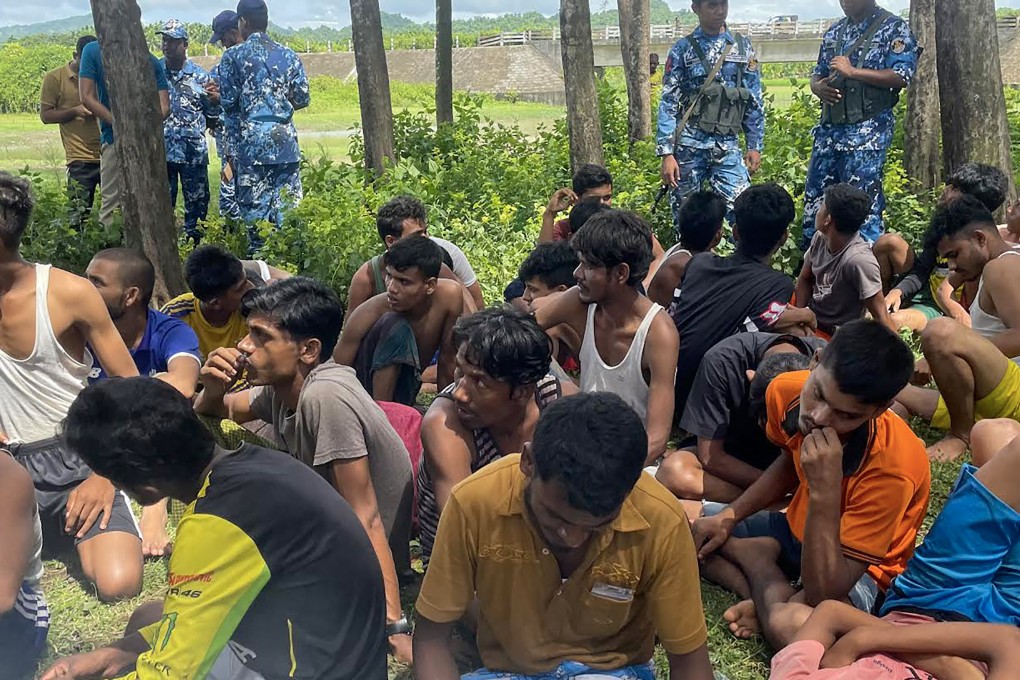 Bangladeshi security personnel stand guard beside Rohingya refugees rescued from a Malaysia-bound boat that sank off the coast of Teknaf in 2022. Photo: AFP