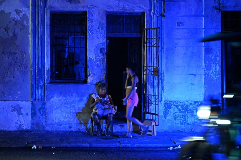 A woman checks a mobile phone during a blackout in Havana’s Centro Habana neighbourhood, Cuba, on June 2. Photo: AFP/Getty Images/TNS