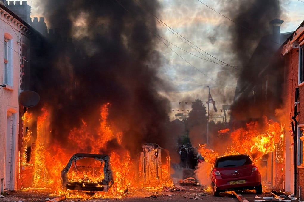 Vehicles set on fire by protesters burn on a street in east Belfast on Tuesday. Photo: PA via AP