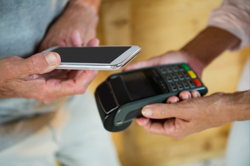 A consumer makes a payment using a mobile phone. Photo: Shutterstock