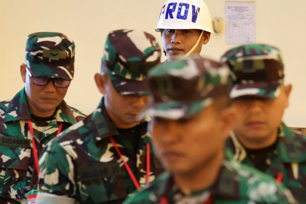 An Indonesian military police officer escorts military personnel charged over an acid attack on human rights activist Andrie Yunus into the courtroom on Wednesday. Photo: Reuters