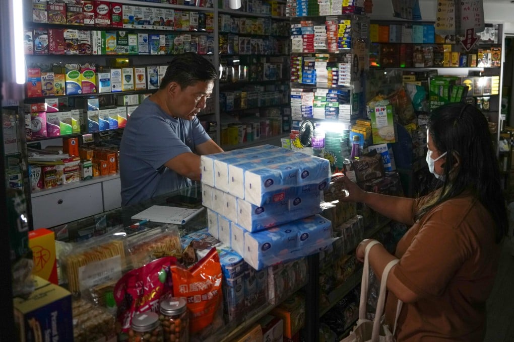 A shopkeeper serves a customer in the dark during a power outage at Tsuen Wan Centre on June 9. The disruption to the supply of electricity and fresh water, caused by an equipment malfunction, affected around 1,000 households. Photo: Sam Tsang