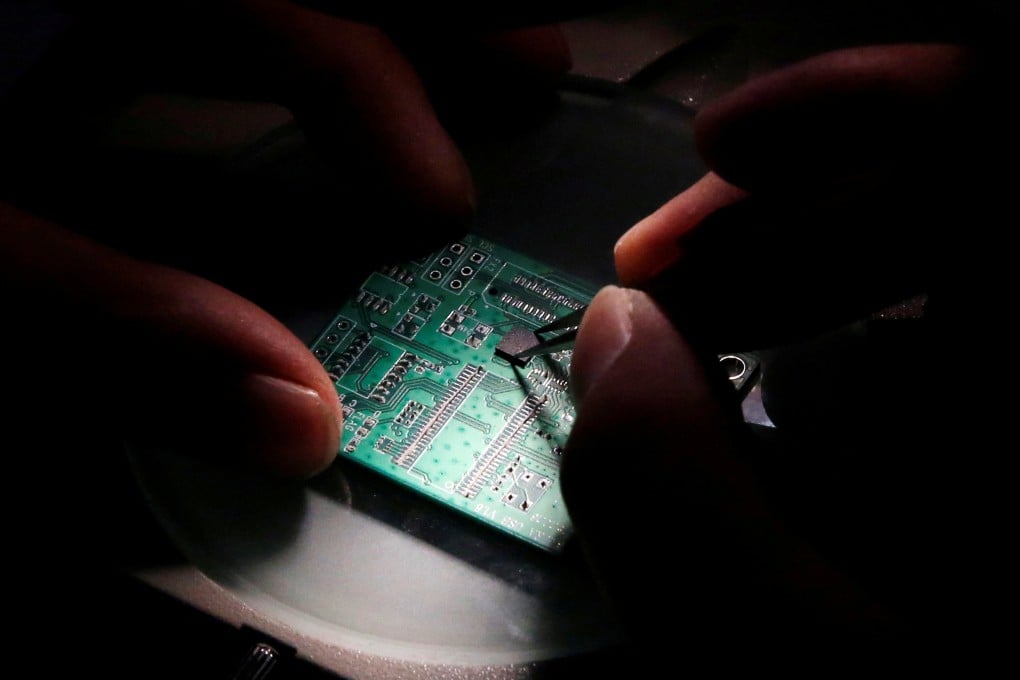 A researcher plants a semiconductor on an interface board. Photo: Reuters