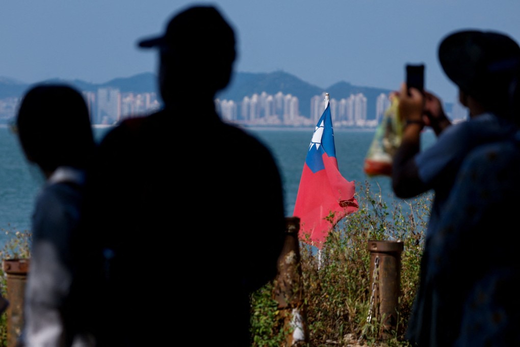 Tourists take photos near a Taiwanese flag on Dadan Island, part of the Quemoy archipelago, also known as Kinmen, which is controlled by Taiwan. The city of Xiamen in Fujian province appears in the background. Photo: Reuters