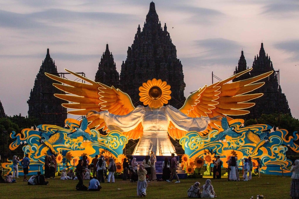 People gather in front of the “Sunflower Angel”, an illuminated nine-metre-tall fibreglass art installation, at Prambanan Temple in Yogyakarta, Indonesia. Photo: AFP