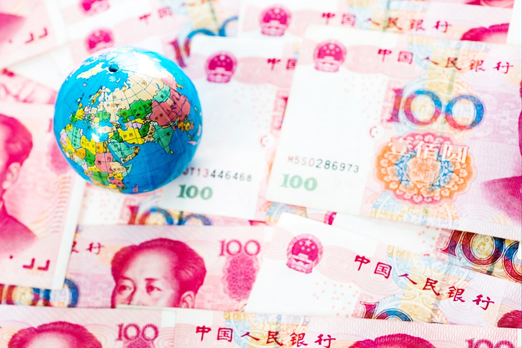 A tiny globe is seen atop a pile of Chinese yuan. Photo: Getty Images