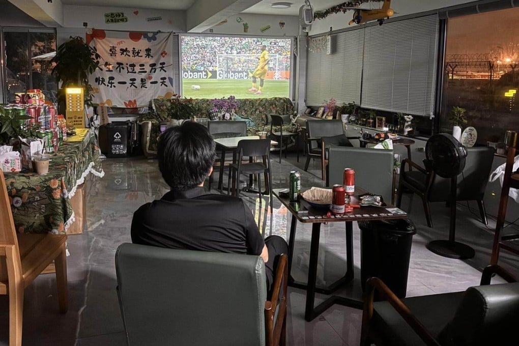 Owner Zhao Chong drinks beer and eats snacks alone as he watches the opening match between Mexico and South Africa at his shop in Hangzhou. Photo: Weibo