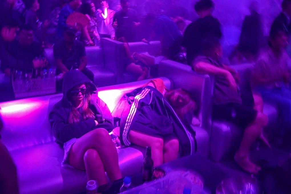 People sleep on a sofa in a nightclub in Yangon while others dance to loud music on May 16 Photo: AFP