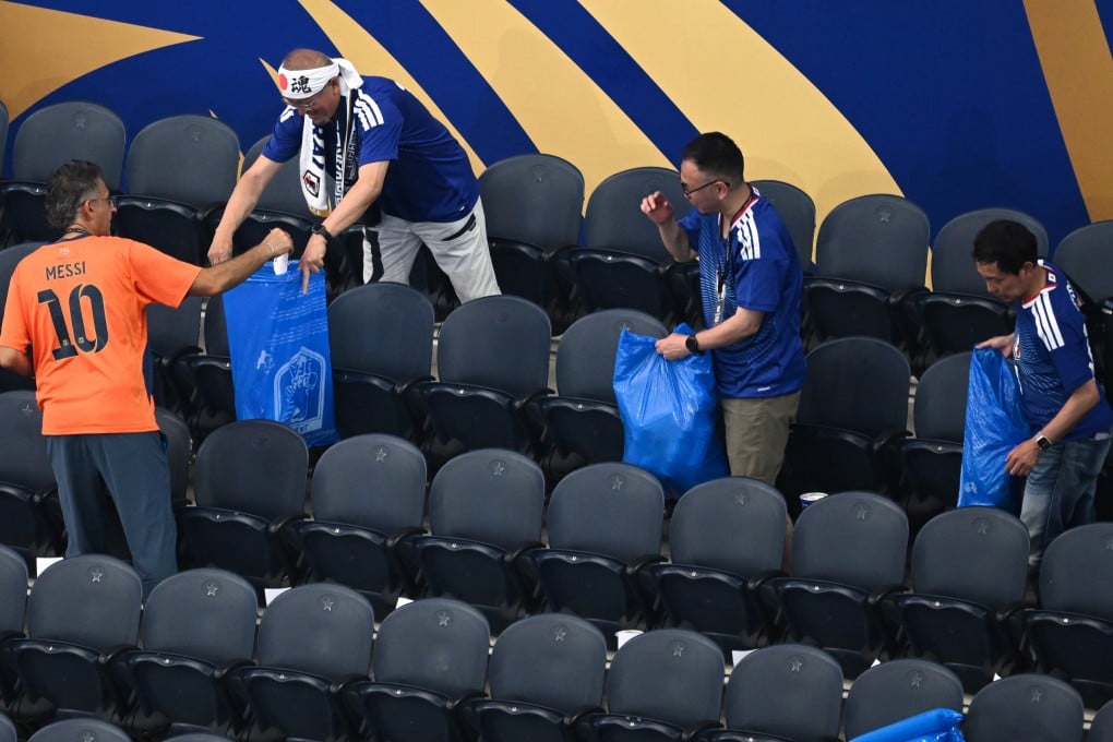 Japan fans put rubbish in blue bin bags after its World Cup against the Netherlands in Arlington, Texas, on Sunday. Photo: AP