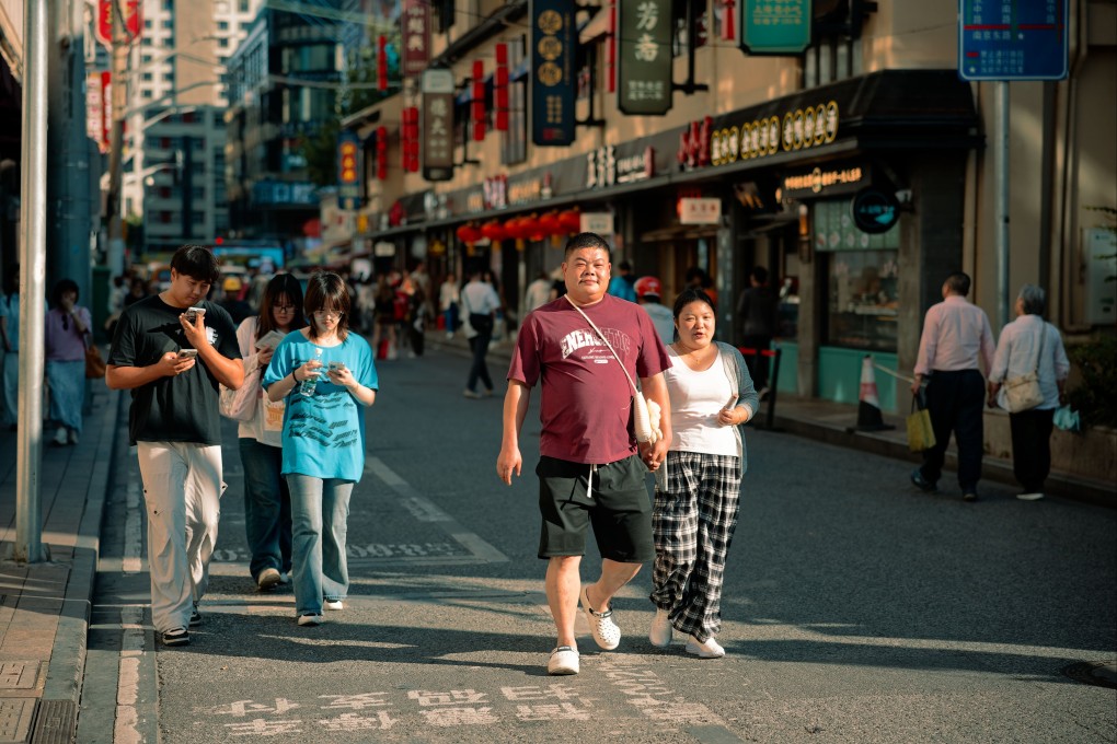 People walk along a street in Shanghai on Tuesday. Households in China are showing a weak appetite for taking on debt. Photo: EPA