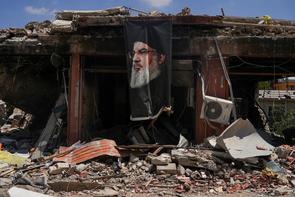 A banner with an image of late Hezbollah leader Hassan Nasrallah hangs from a building destroyed in an air strike in Jibchit, Lebanon, on Tuesday. Photo: Reuters
